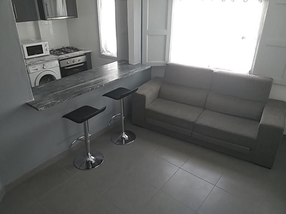 a living room with a couch and two stools at Buarcos-Figueira de Foz in Figueira da Foz