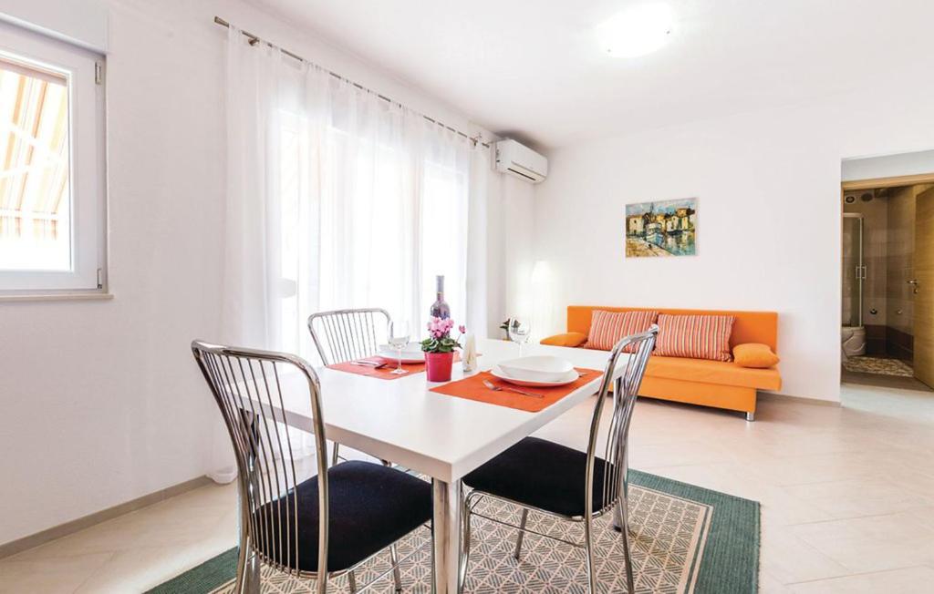 a dining room with a white table and chairs at Apartment VESNA in Selce