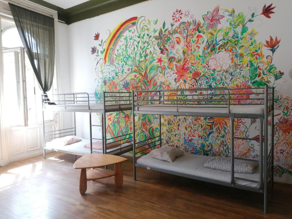 ブダペストにあるBlack Dog Hostelの二段ベッド3組が備わるカラフルな壁の客室です。