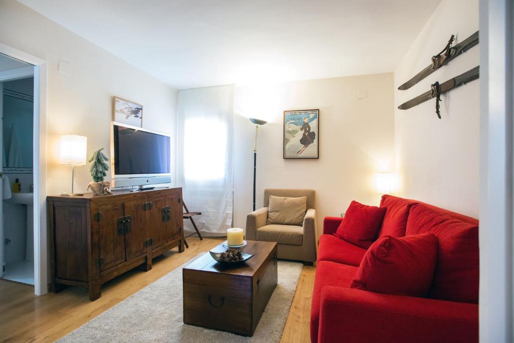 福米加尔Foratata By PIRINEOS360 Formigal - 3 dormitorios Y 2 baños的客厅里有一张红色沙发和一台电视