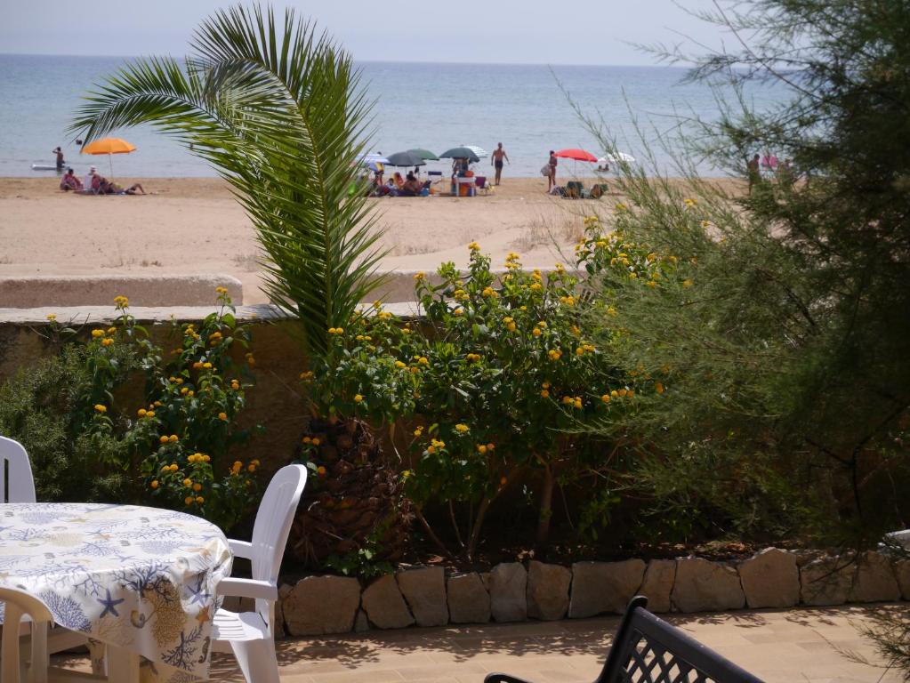 a table and chairs with a view of the beach at Tre Fontane sul Mare in Tre Fontane