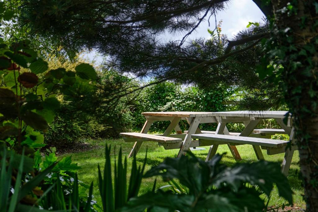 a picnic table sitting in the grass under a tree at The Westleton Crown in Westleton