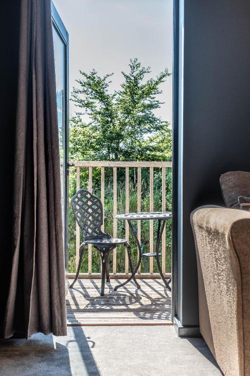 a balcony with a chair and a table on a porch at The Westleton Crown in Westleton