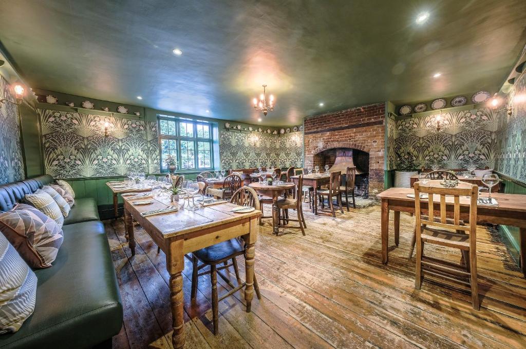 a restaurant with tables and chairs and a fireplace at The Westleton Crown in Westleton