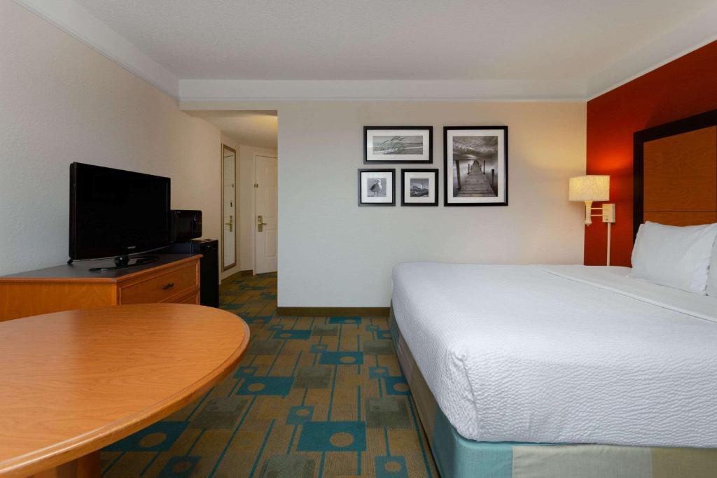a hotel room with a bed and a flat screen tv at La Quinta by Wyndham Lakeland West in Lakeland