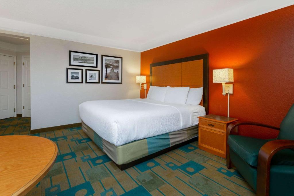 a hotel room with a bed and a table and a chair at La Quinta by Wyndham Lakeland West in Lakeland