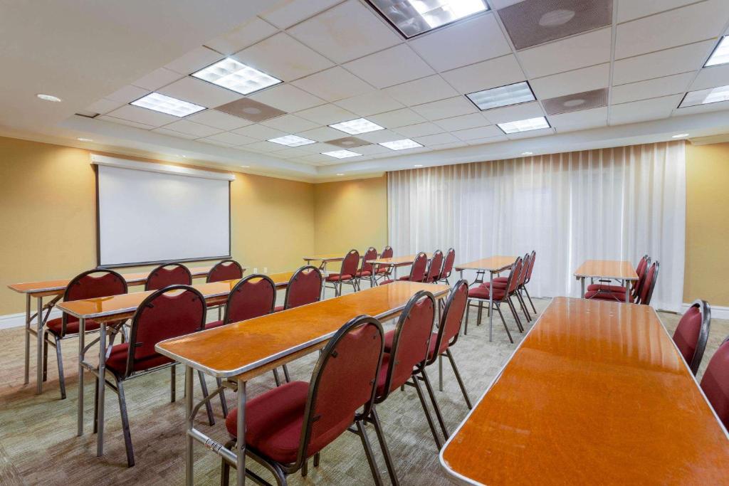 a conference room with tables and chairs and a whiteboard at La Quinta by Wyndham Lakeland West in Lakeland