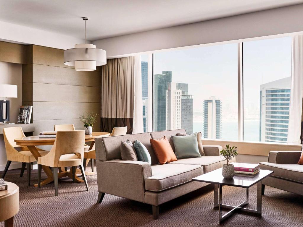 a living room with a couch and a table at Pullman Doha West Bay in Doha