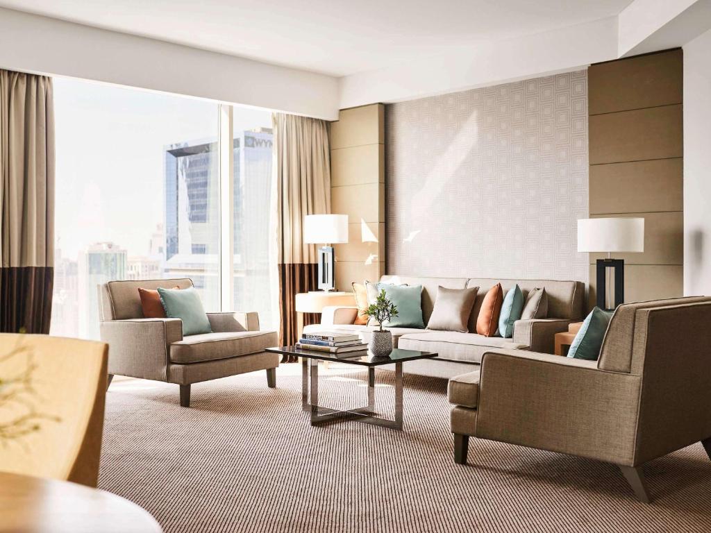 a living room with two chairs and a couch at Pullman Doha West Bay in Doha