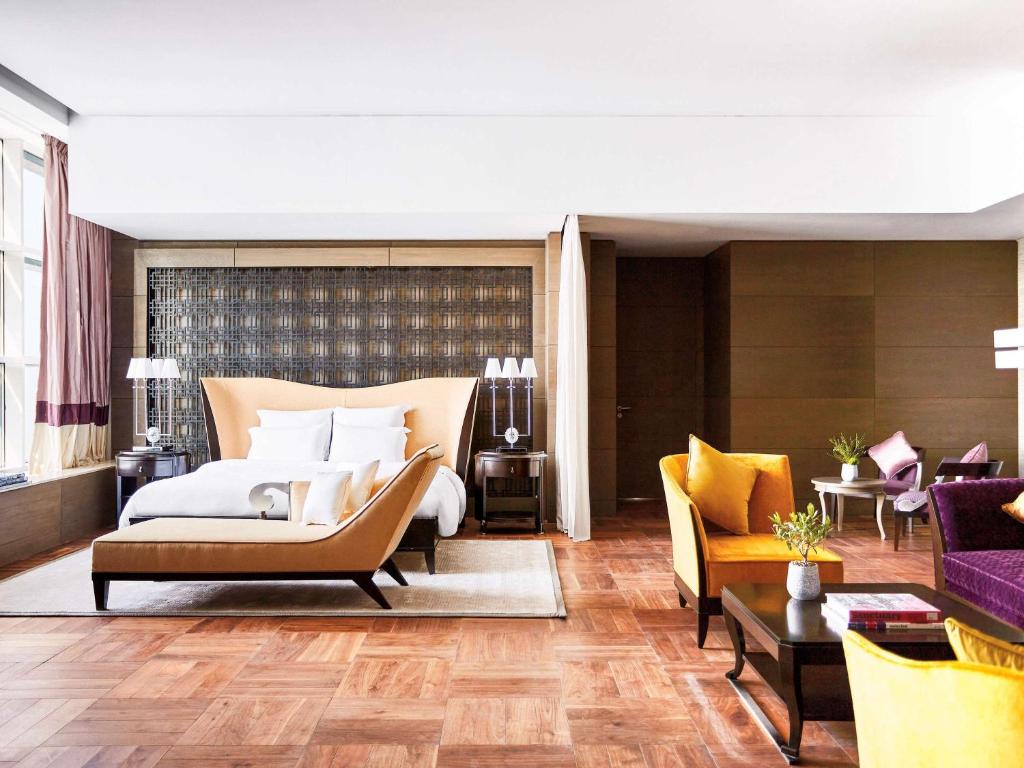 a bedroom with a bed and a living room at Pullman Doha West Bay in Doha