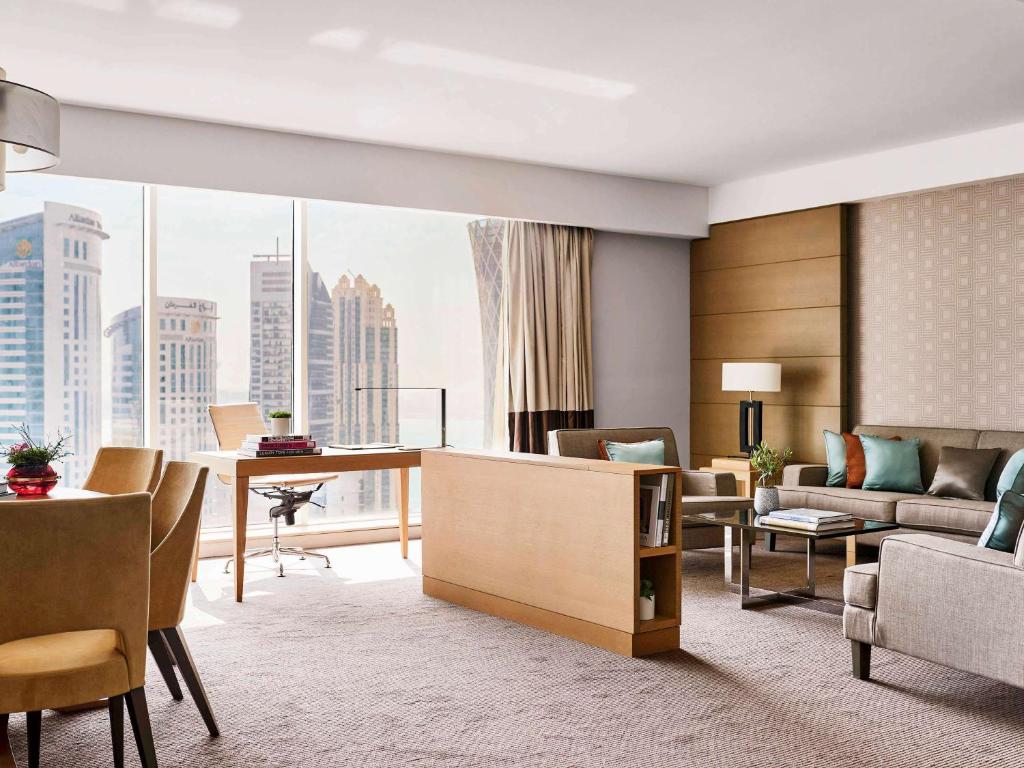 a living room with a view of a city at Pullman Doha West Bay in Doha