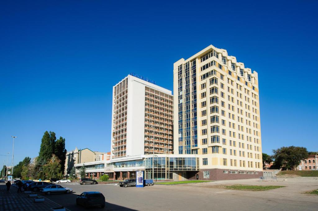dos edificios altos al lado de un estacionamiento en Slovakia Hotel, en Saratov