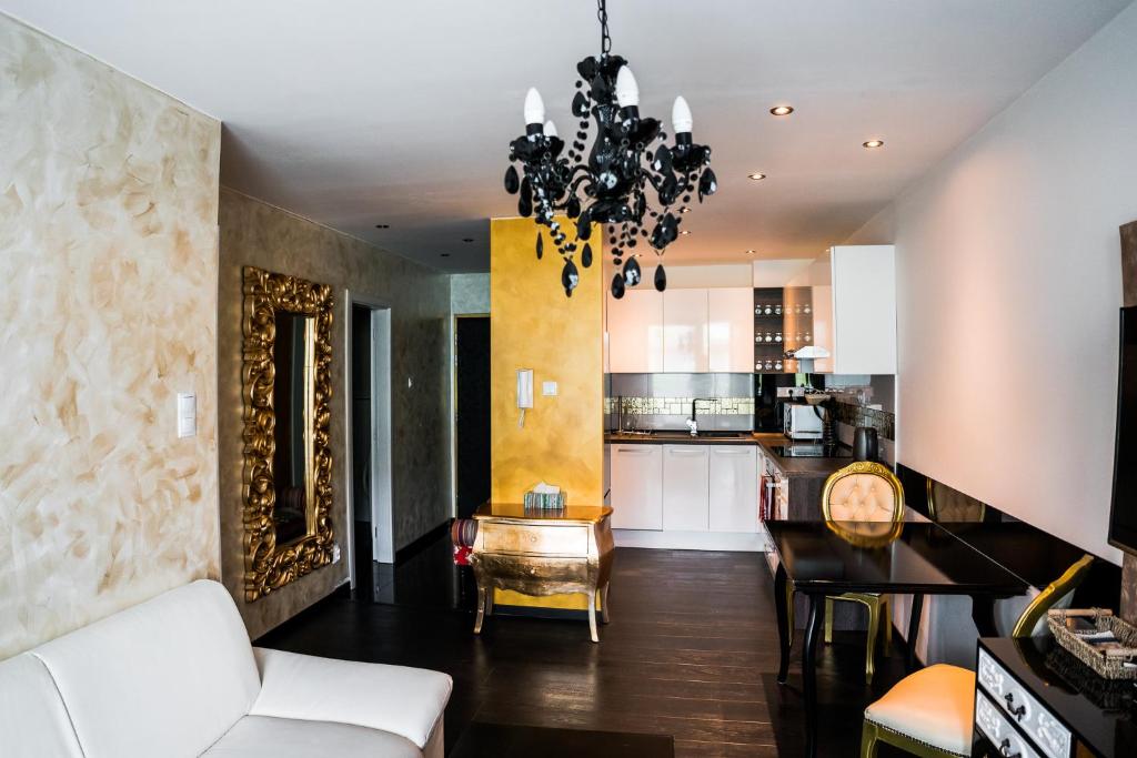 sala de estar y cocina con lámpara de araña en AH Luxury Galerka, en Košice