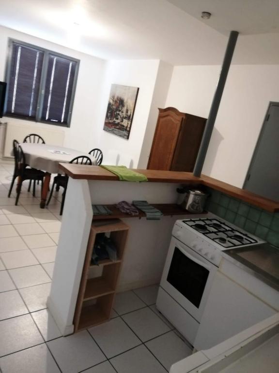 une cuisine avec une cuisinière et un comptoir dans l'établissement appartement simple entier avec cour pour 2 a 7 personnes, à Château-Gontier