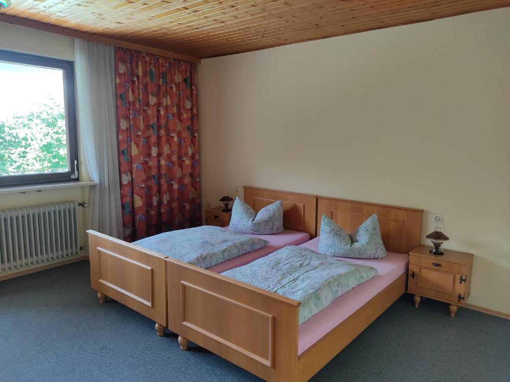 1 dormitorio con 2 camas y ventana en Pension Bachlhof, en Fürsteneck