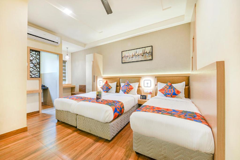 Dos camas en una habitación de hotel con una habitación en Nestlay Rooms Vanagaram, en Chennai