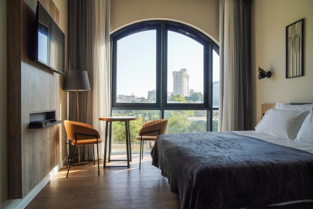 a hotel room with a bed and a large window at Apartique Hotel in Jerusalem