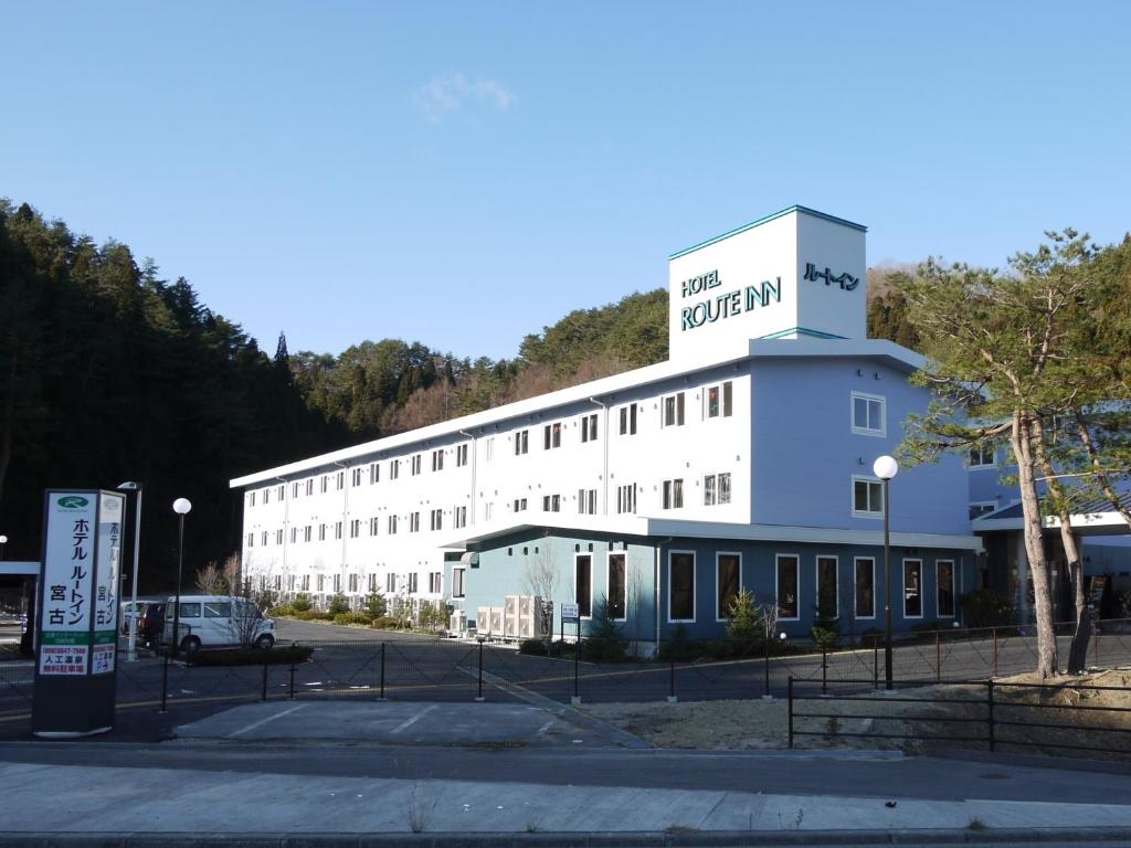 Un bâtiment blanc avec un panneau en haut dans l'établissement Hotel Route-Inn Miyako, à Miyako