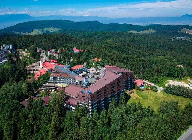 an aerial view of a building in the middle of a forest at Poiana Brasov Alpin Executive Apartment in Poiana Brasov