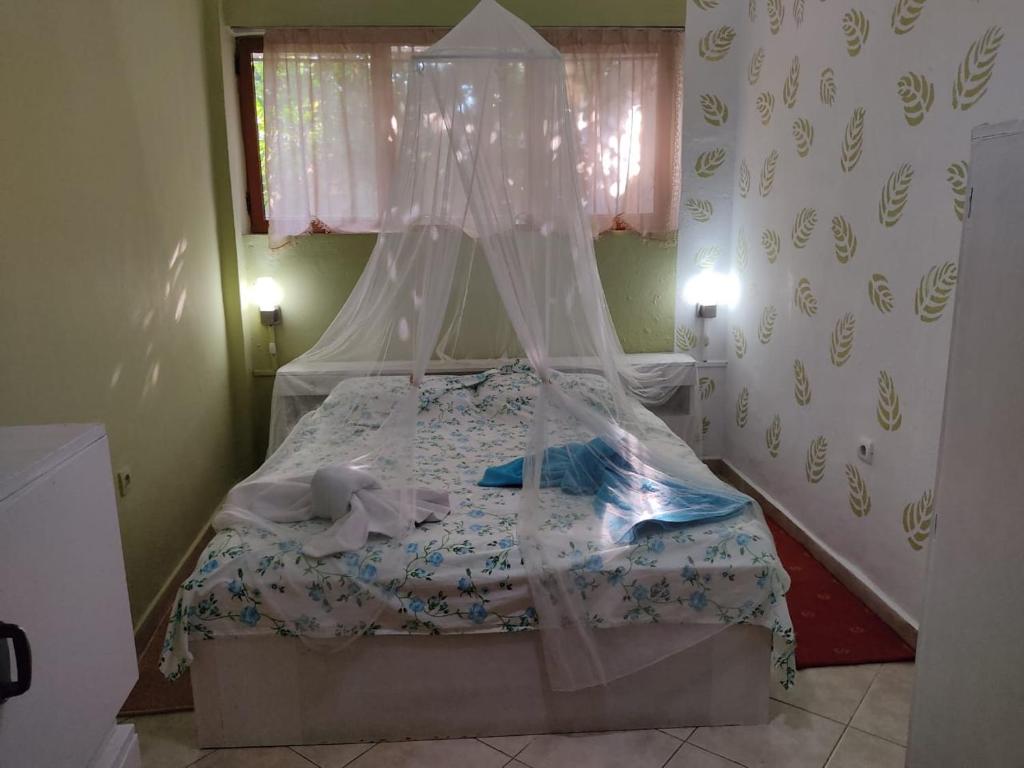 a small bedroom with a bed with a canopy at Private Apartment Elbasan Historic Center in Elbasan