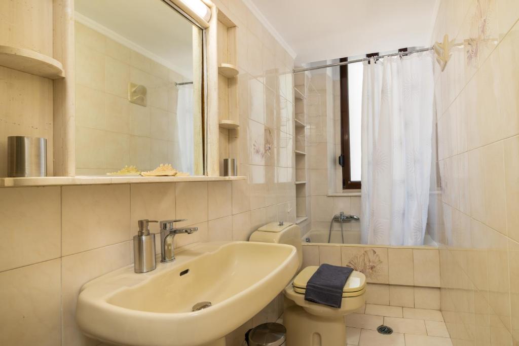 biała łazienka z umywalką i toaletą w obiekcie La Casa di Efi w mieście Rodos
