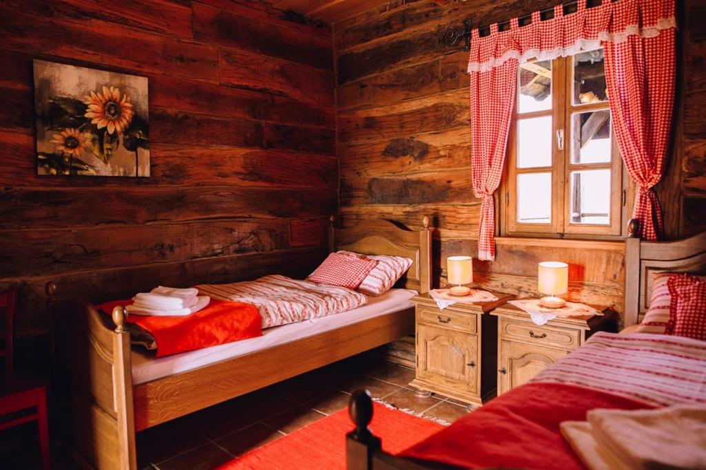 a bedroom with two beds in a log cabin at Kuća za odmor Stara hiža in Selnica