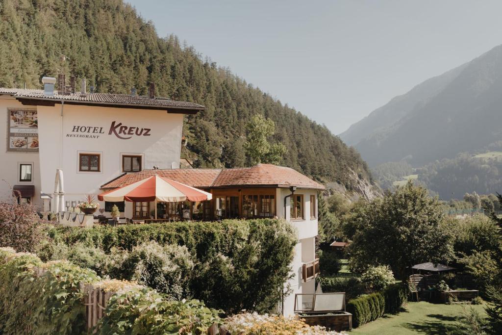 a hotel in a valley with a mountain at Hotel Kreuz in Pfunds