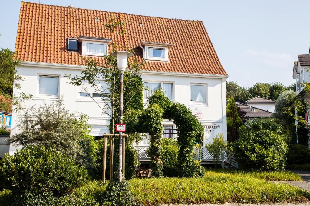 ein weißes Haus mit orangefarbenem Dach in der Unterkunft Ferienanlage Duhnen in Cuxhaven