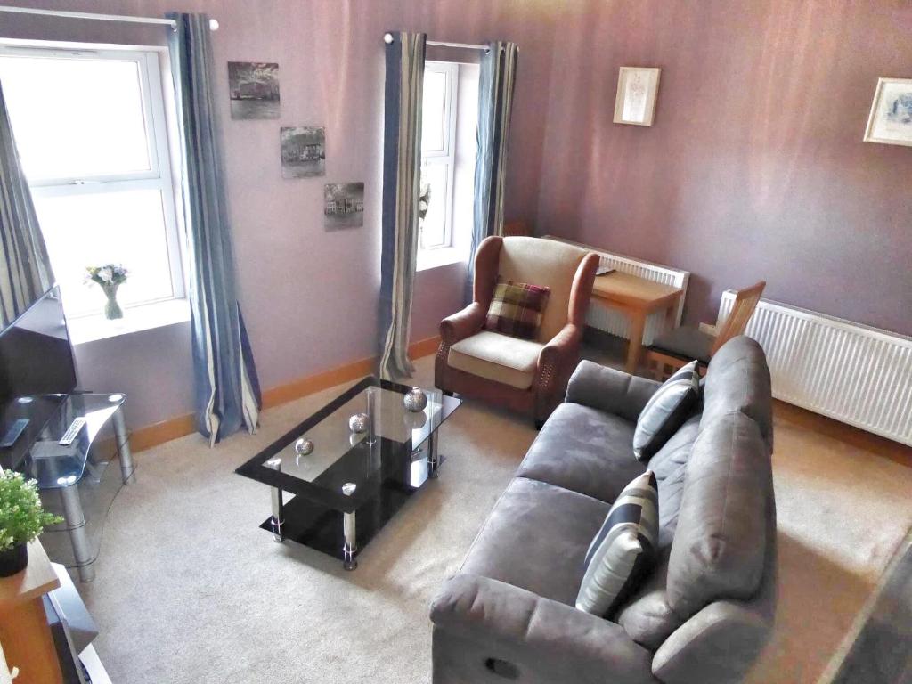 a living room with a couch and a chair at Gwynedd House Flat 2 in Pentraeth