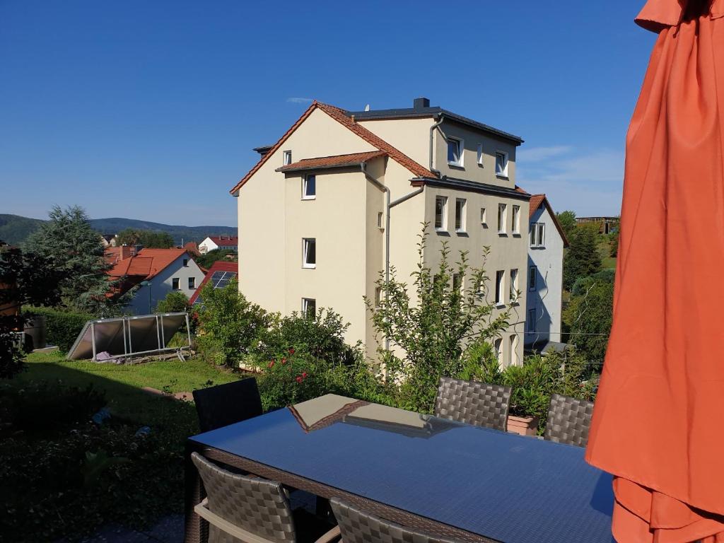a house on a hill with a table and an umbrella at Ferienwohnung Willi B. in Eisenach