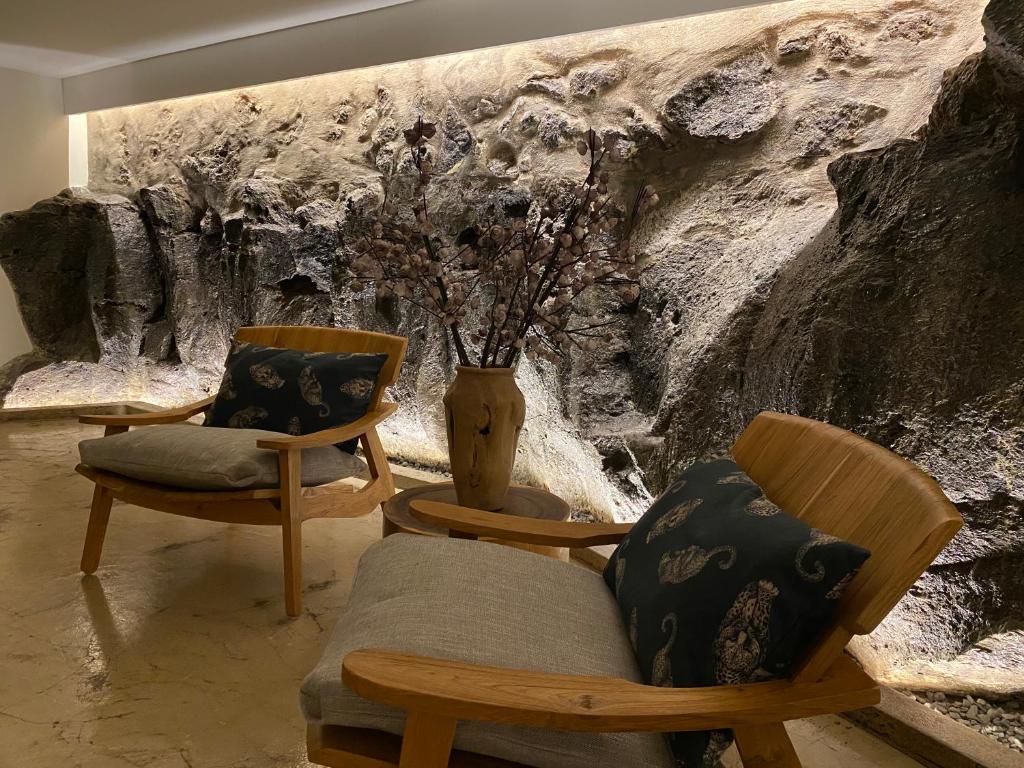 a room with two chairs and a painting on the wall at LUZZ me - Casas de Santa Bárbara in Santa Bárbara