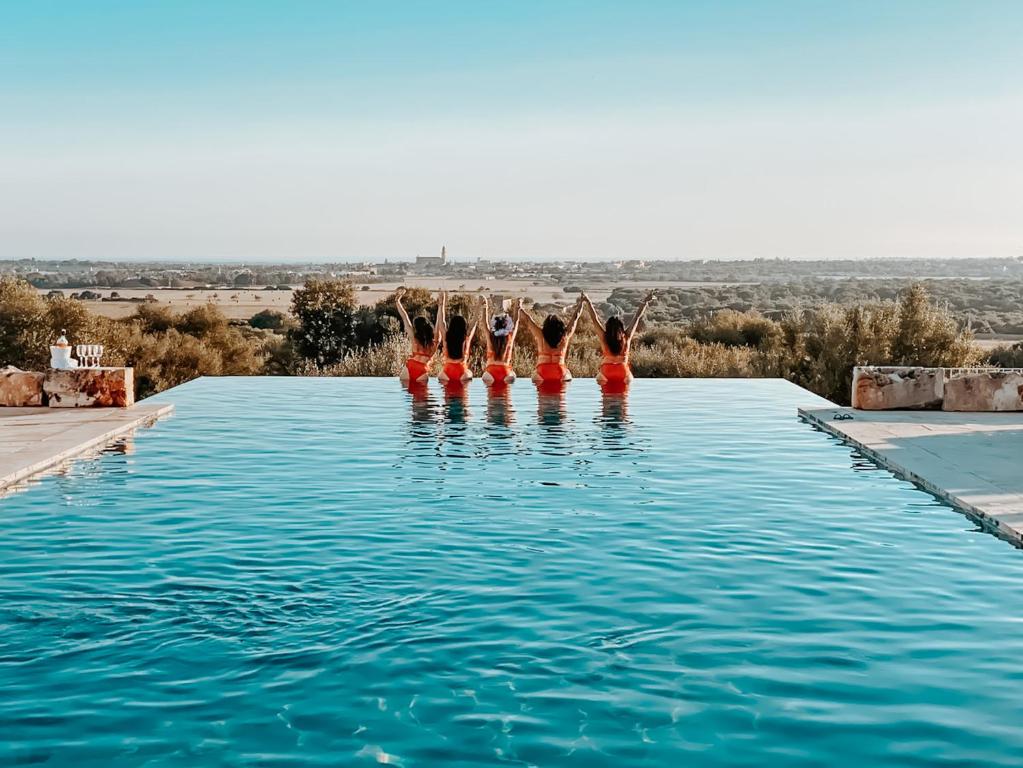 a group of people in the water in a swimming pool at Finca Hotel Rural Es Turó in Ses Salines