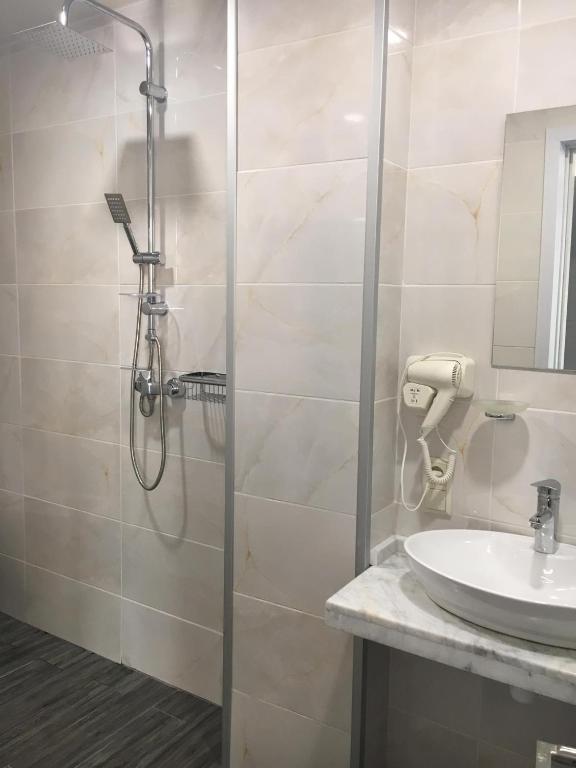 a bathroom with a shower and a sink at Hotel Scala in Shekhvetili