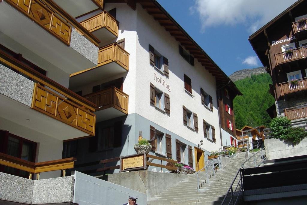 a building with wooden balconies on the side of it at Apartmenthaus Holiday in Saas-Fee
