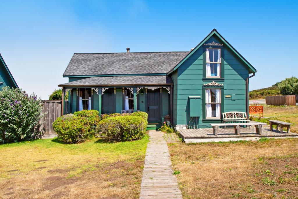 a green house with a bench in front of it at Headlands View in Mendocino