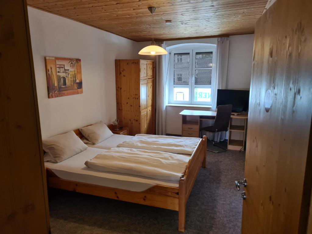 a bedroom with a bed and a desk with a computer at Hotel & Gasthof zur Post in Neumarkt-Sankt Veit