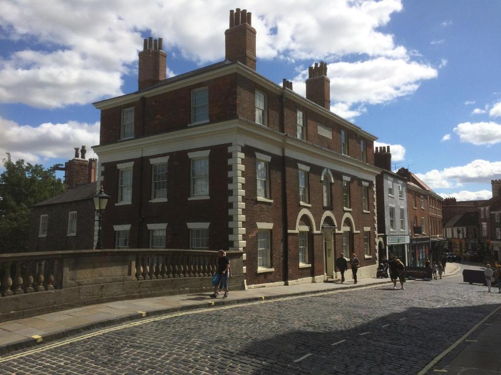 a large brick building on a cobblestone street at City Centre - The Old Committee Room-free parking in York