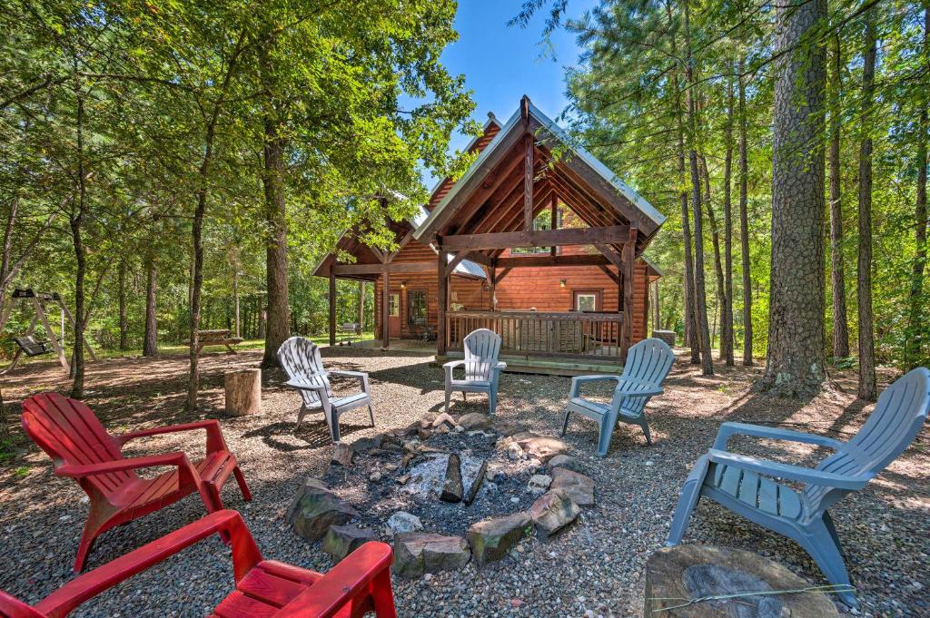 um grupo de cadeiras sentadas à volta de uma lareira em frente a uma cabina em Cabin with Games and Hot Tub, 4 Mi to Beavers Bend! em Broken Bow