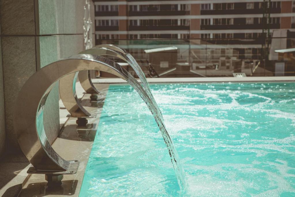 a swimming pool with a water fountain in a building at Zenit Convento San Martin in San Sebastián
