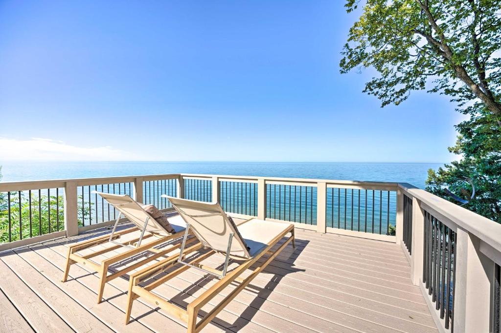 2 sillas sentadas en una terraza con vistas al océano en Modern Lake Michigan Home with 3 Lakefront Decks!, en Holland