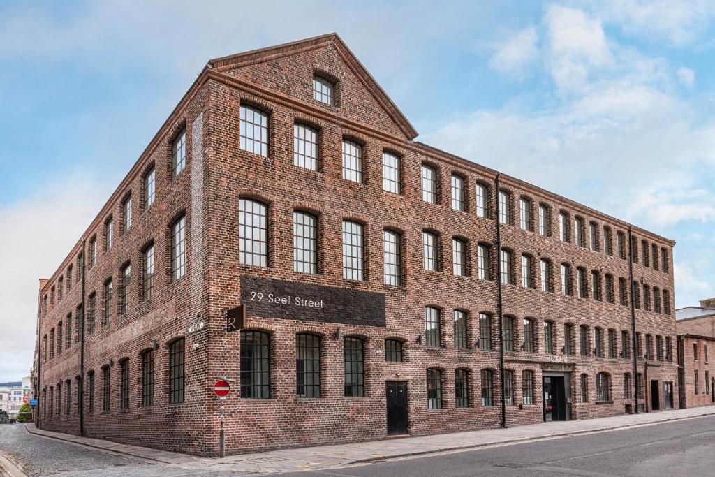 um grande edifício de tijolos ao lado de uma rua em The Resident Liverpool em Liverpool