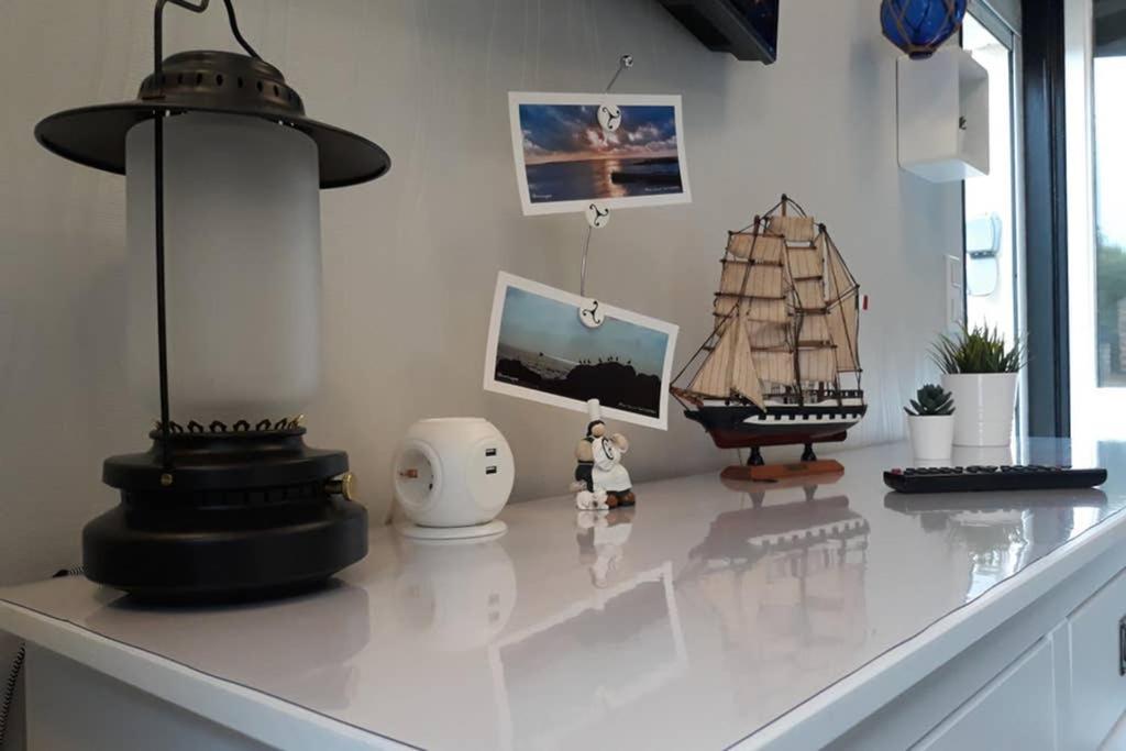 ein weißer Schreibtisch mit einem Modellschiff drauf. in der Unterkunft Le cottage de Guidel in Guidel