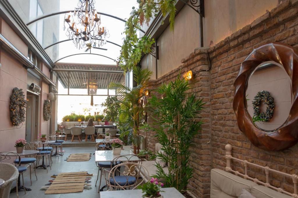 a room with tables and chairs and a brick wall at Marpessa Hotel & Spa in Agrinion