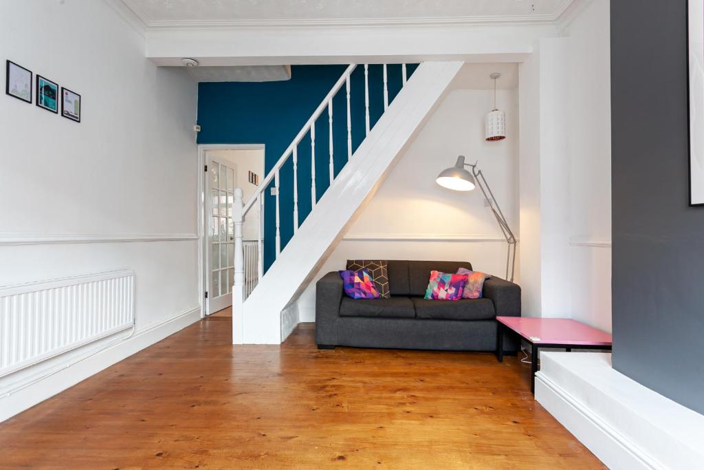 a living room with a couch and a staircase at Chic 3 Bed House for up to 6 people in the city of Manchester in Manchester