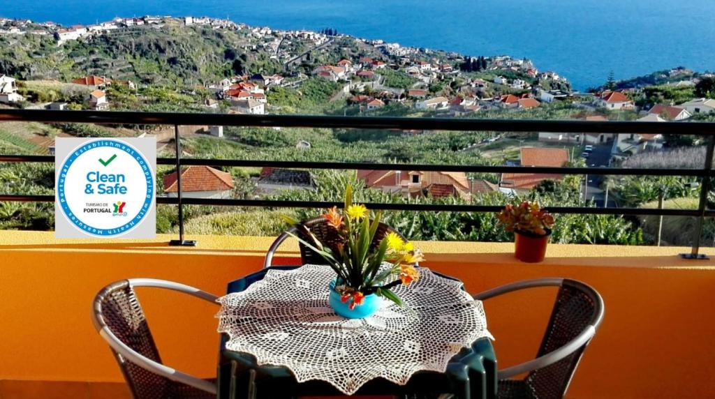 - une table avec un vase de fleurs sur le balcon dans l'établissement Lindo Apartamento Villa, à Ponta do Sol