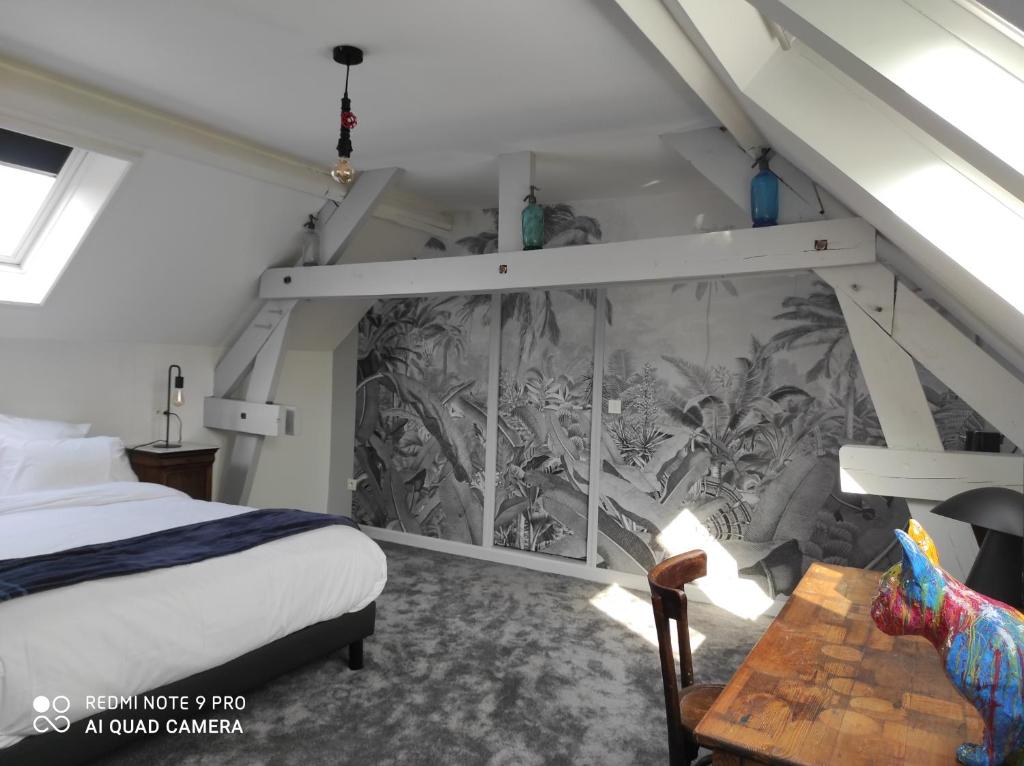 - une chambre avec un lit et une fresque murale dans l'établissement Letabli, à Ennetières-en-Weppes