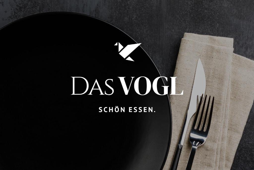 a black plate with a knife and fork on a table at HAIDVOGL MAVIDA Zell am See in Zell am See