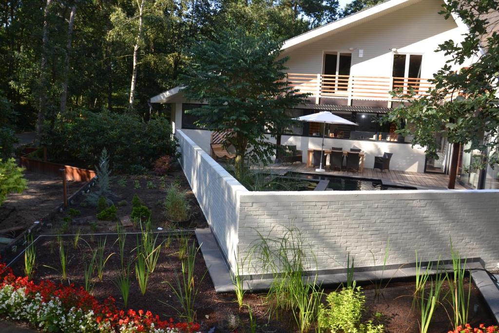 une maison avec un jardin fleuri devant elle dans l'établissement B&B Wepa-hof, à Oud-Turnhout