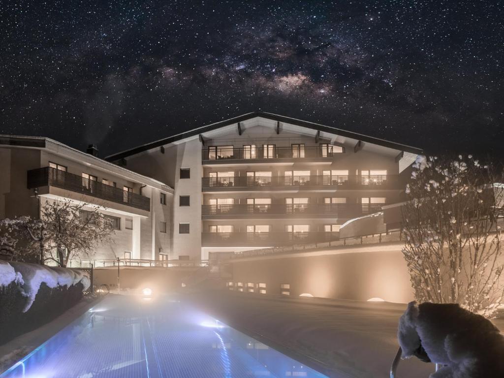 a building with a swimming pool at night at HAIDVOGL MAVIDA Zell am See in Zell am See