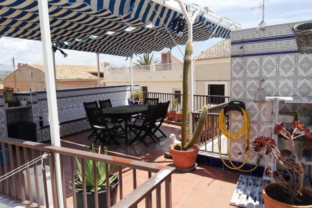 a patio with a table and chairs and an umbrella at Casa con terraza/Confortable house with terrace in Aigues